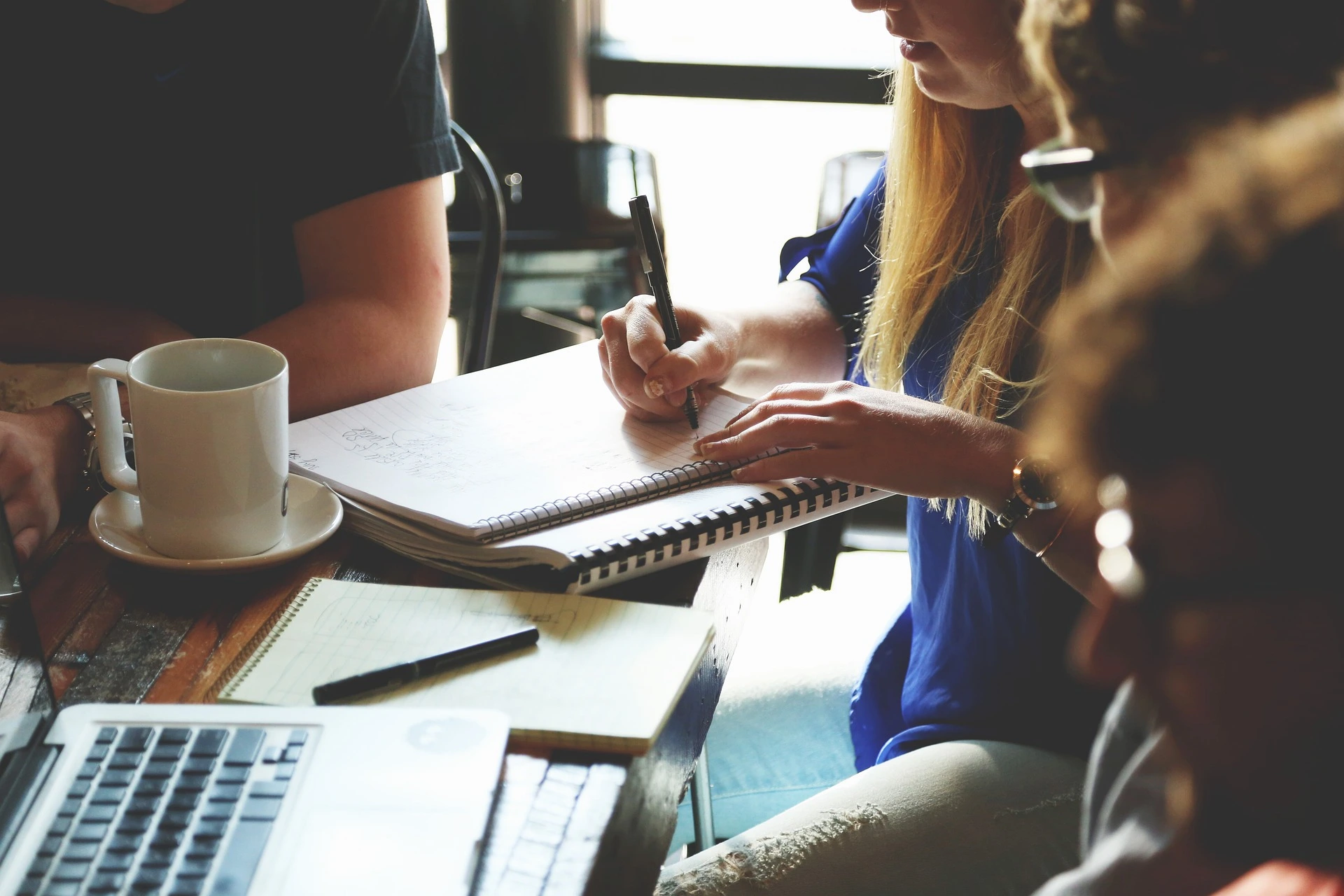 Picture of people discussing with notebooks on the table